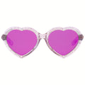 Heart-shaped sunglasses with bright pink lenses and a sparkling silver glitter frame, shown against a plain white background.