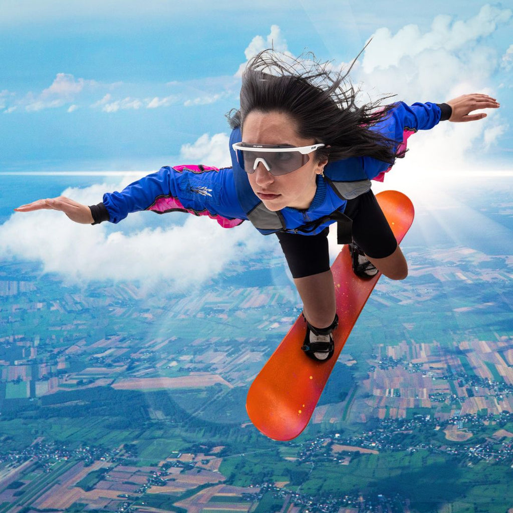 Woman pretends to fly wearing The Miami Nights Skysurfer with a Photochromic Smoke lens from Pit Viper Sunglasses