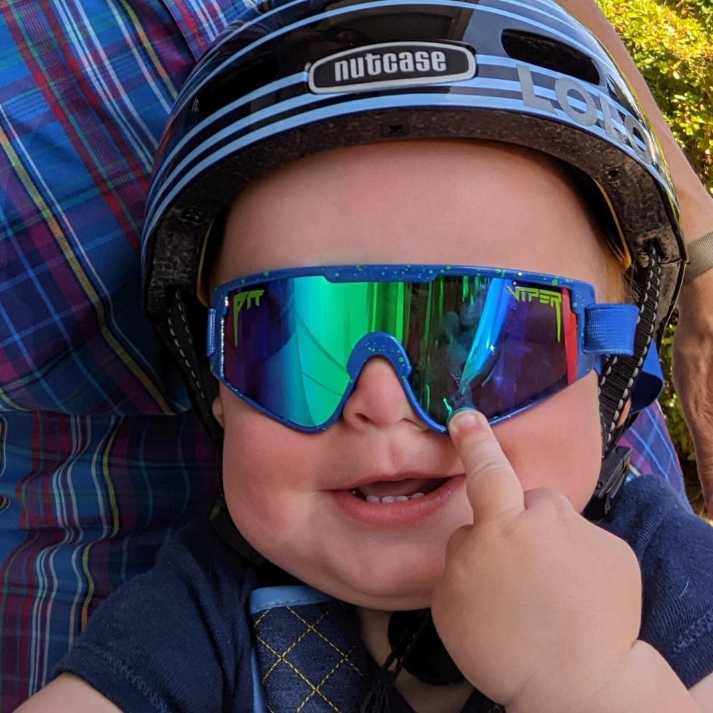 Baby wearing a helmet and The Leonardo Baby Vipes from Pit Viper Sunglasses