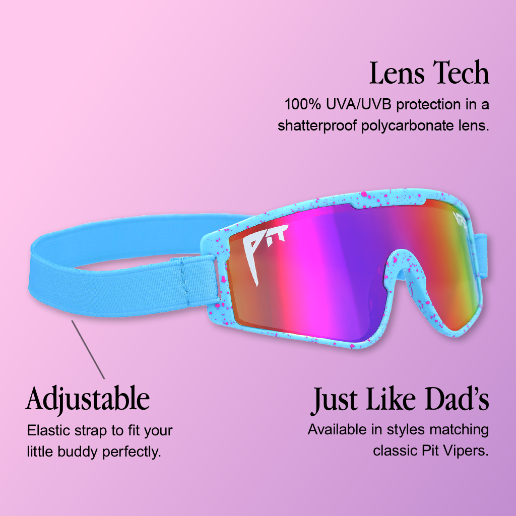 Infographic for Pit Viper Baby Vipes kids goggles showing a side/angled view of a light blue goggle frame speckled with pink dots, a light blue elastic strap, a rainbow (red-purple-yellow-green) mirrored lens with 'PIT' text, set against a pink-to-lavender gradient background with 3 callouts: 'Lens Tech - 100% UVA/UVB protection in a shatterproof polycarbonate lens.', 'Adjustable - Elastic strap to fit your little buddy perfectly.', "Just Like Dad's - Available in styles matching classic Pit Vipers."