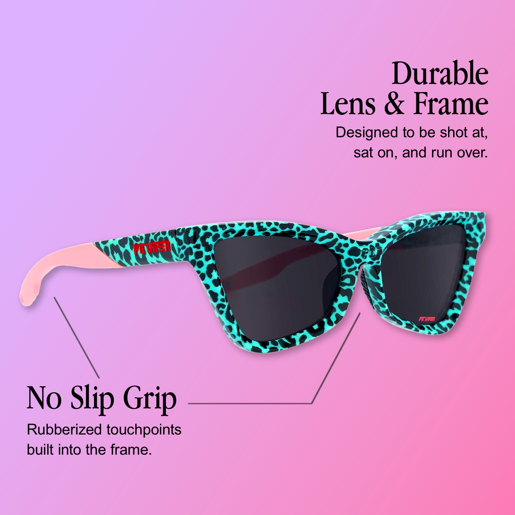 Infographic for Pit Viper Clawdia sunglasses showing a side-angle view of a cat-eye-style frame in mint teal-and-black leopard print with pink temple arms bearing a small red 'PIT VIPER' logo and dark gray lenses, set against a purple-to-pink gradient background, with 2 callouts: 'Durable Lens & Frame - Designed to be shot at, sat on, and run over.', 'No Slip Grip - Rubberized touchpoints built into the frame.'