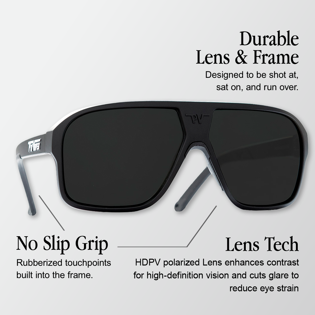 Infographic for Pit Viper Flight Optics HDPV Polarized sunglasses showing a large black aviator-style shield frame with dark black polarized lenses, a 'PV' logo on the bridge, and a 'PIT VIPER' logo on the temple, viewed from the side, with 3 callouts: 'Durable Lens & Frame - Designed to be shot at, sat on, and run over.', 'No Slip Grip - Rubberized touchpoints built into the frame.', 'Lens Tech - HDPV polarized Lens enhances contrast for high-definition vision and cuts glare to reduce eye strain'