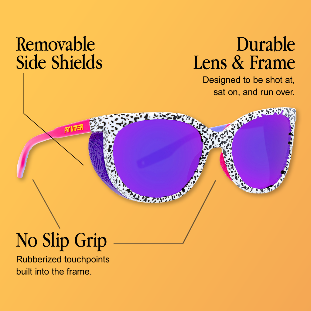 Infographic for Pit Viper Fondue cat-eye sunglasses showing a black-and-white speckled cow-print frame with pink temple arms bearing yellow 'PIT VIPER' text and purple mirrored lenses, set against an orange-yellow gradient background, with 3 callouts: 'Removable Side Shields', 'Durable Lens & Frame - Designed to be shot at, sat on, and run over.', 'No Slip Grip - Rubberized touchpoints built into the frame.'