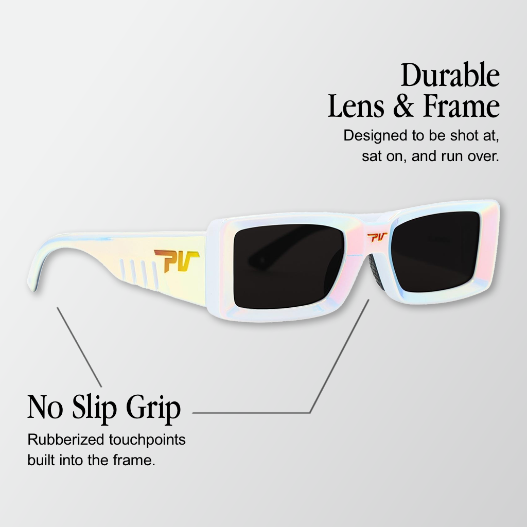 Infographic for Pit Viper Low Bones sunglasses showing a chunky rectangular pearlescent iridescent white frame with black rectangular lenses and an orange/gold 'PV' logo on the temple, set against a light gray background, with 2 callouts: 'Durable Lens & Frame - Designed to be shot at, sat on, and run over.', 'No Slip Grip - Rubberized touchpoints built into the frame.'