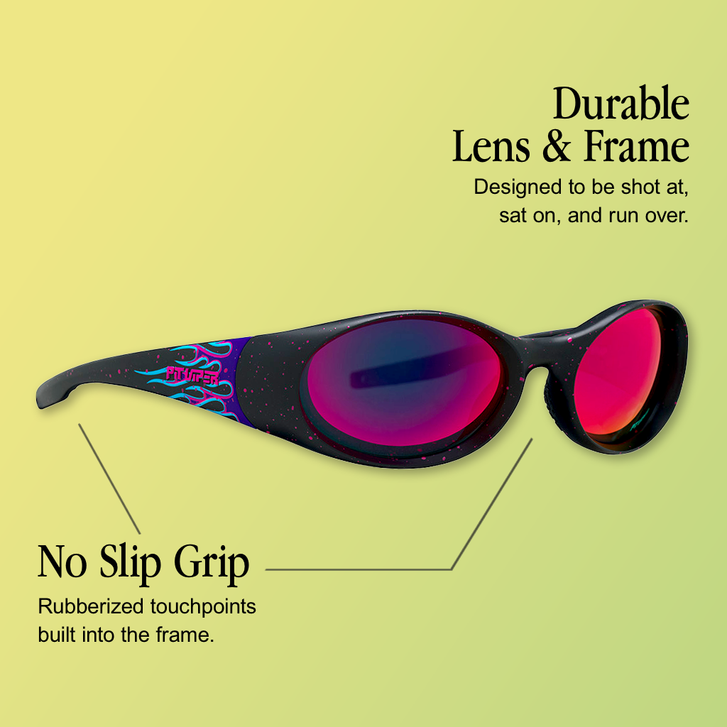Infographic for Pit Viper Slammer sunglasses showing a black speckled oval-lens wraparound frame with a purple and teal flame graphic and pink 'PIT VIPER' text on the temple, pink-to-purple mirrored lenses, set against a yellow-green gradient background, with 2 callouts: 'Durable Lens & Frame - Designed to be shot at, sat on, and run over.', 'No Slip Grip - Rubberized touchpoints built into the frame.'